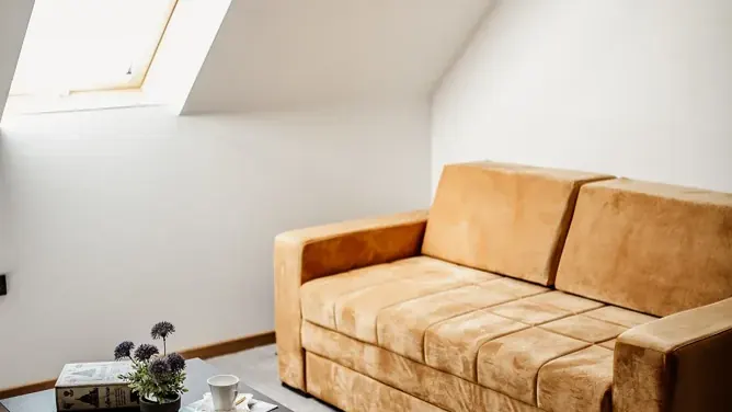 Sala com sofá ocre e iluminação natural